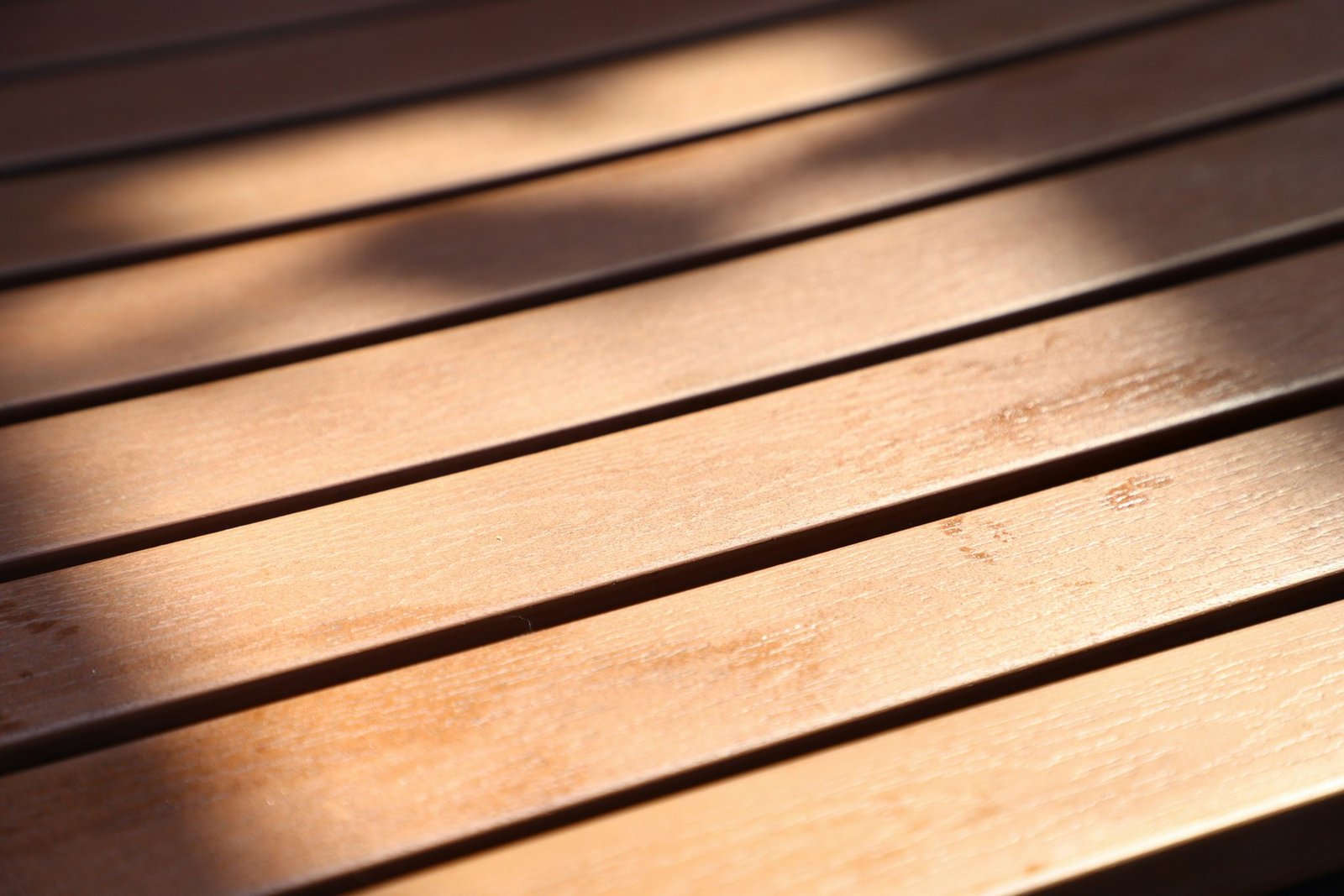 Holzterrasse wird mit Reiniger gesäubert